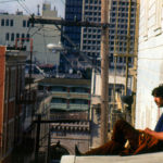 3 Hippie Sitting on Street Sunning